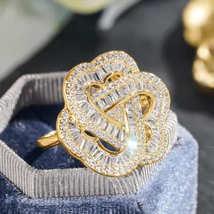 Macro view of gold flower heart ring with zircon stones in a blue velvet box