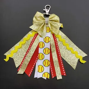 Macro detail of baseball theme bow keychain with gold glitter and sport ribbons
