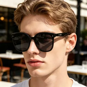 Close-up shot of stylish black square polarized sunglasses worn by a male model outdoors