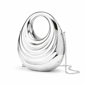 Detailed view of silver metallic egg-shaped evening bag with wavy texture and chain strap