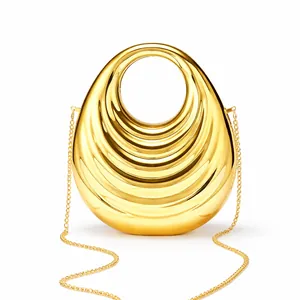 Detail of gold hard shell evening clutch with wave pattern and metal chain strap