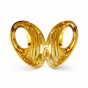 Detail of a golden butterfly-shaped clutch bag with polished mirror finish and magnetic clasp