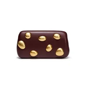 Detail of burgundy leather clutch featuring artistic gold pebble-shaped metal ornaments