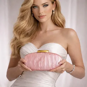 Detailed shot of a pale pink acrylic shell clutch with marble pattern and gold clasp