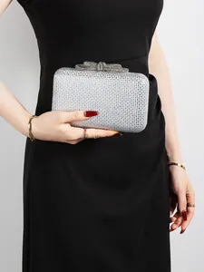Close-up of sparkling silver rhinestone clutch featuring a decorative crystal bow clasp