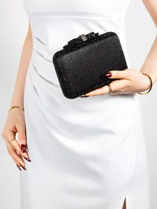 Close-up of elegant black rhinestone evening clutch bag with metal clasp and diamond texture