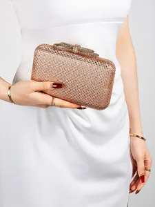 Detail view of champagne gold evening clutch with rhinestones and crystal bow clasp closure
