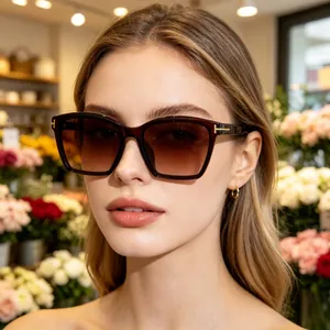 Elegant cat-eye sunglasses with brown gradient lenses and signature gold T-hinge detail