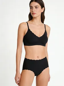 Dettaglio di un set intimo nero senza cuciture con bordi smerlati su sfondo bianco studio
