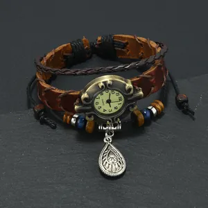 Detail of vintage bronze watch dial with leather strap, wooden beads and metallic pendant