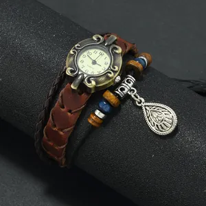 Detail of vintage bronze watch case and brown braided leather strap with beads
