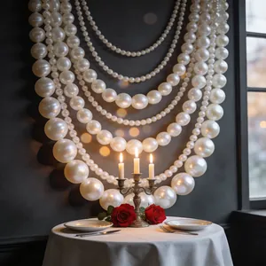 Elegant oversized faux pearl necklaces draped on a dinner table with candles and roses