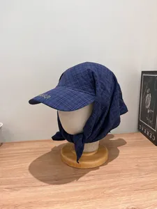 Detailed embroidery of freedom text on dark blue checkered sun hat with tying straps