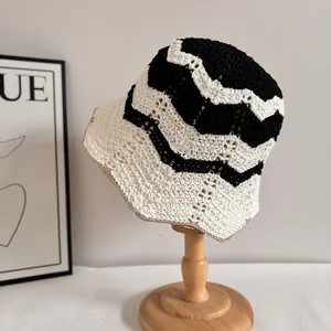 Detalle del gorro de pescador tejido a mano con patrón de ondas blanco y negro en soporte