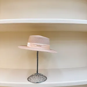 Sombrero de paja rosa con cinta plisada y logo metálico para protección solar de verano