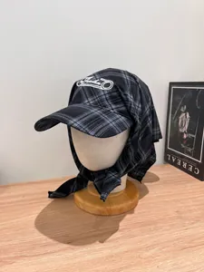 Close-up of black and grey plaid beret with Freedom embroidery and scarf detail