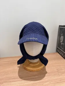 Detail of navy plaid sun hat scarf with white Freedom embroidery and tie straps