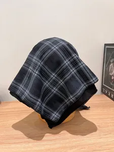 Close-up of lightweight plaid fabric bandana showing refined sewing and blue-grey checkered pattern