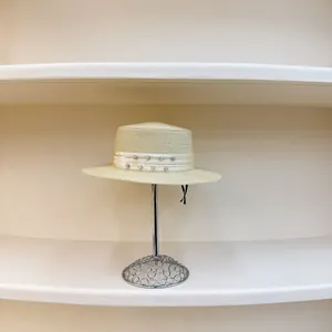 Elegante sombrero de paja beige con cinta adornada de strass en soporte metálico