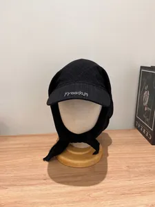Detail of black fabric headscarf cap with Freedom embroidery on the curved brim