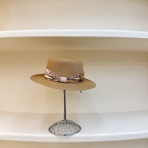 French vintage brown straw flat top hat with floral ribbon and pearl accents on stand