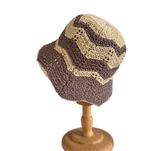 Sombrero de pescador de ganchillo con ondas marrones y beige en soporte de madera