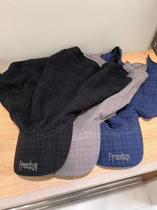 Detail of three quick-dry caps in black, gray, and blue with Freedom embroidery