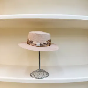 Detail of pink boater hat with floral ribbon and elegant rectangular pearl buckle