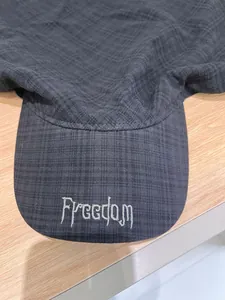 Close-up of dark grey sun hat featuring Freedom embroidery and textured grid fabric