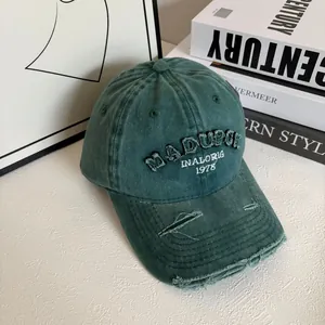 Close-up of distressed cotton baseball cap with embroidered letters and torn details
