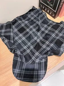 Detail of classic black and white plaid beret on wooden surface with magazine
