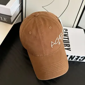 Close-up of white letter embroidery on a brown vintage cotton baseball cap side