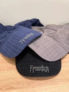 Close-up of textured checkered fabric and Freedom embroidery on three colorful sun hats