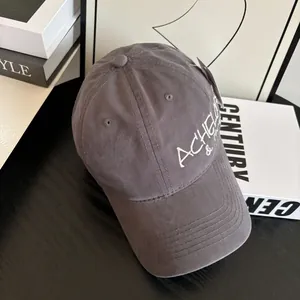 Detailed embroidery of white letters on a dark grey vintage distressed baseball cap