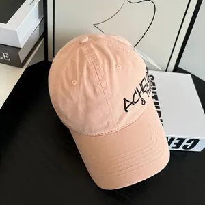 Side view of pink distressed baseball cap with black letter embroidery on cotton fabric