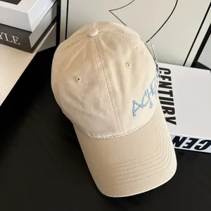 Close-up of blue ACHELO embroidery on a beige vintage cotton baseball cap detail