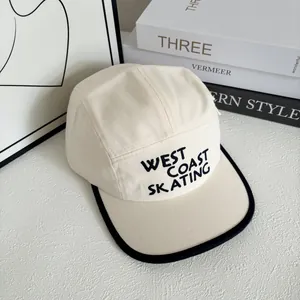Detail of five-panel camp hat with West Coast Skating embroidery and black piping