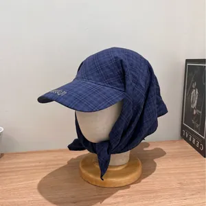 Navy blue checkered sun hat with integrated headscarf and long brim on a mannequin