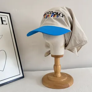 Detailed embroidery on a cream and blue sun protection cap with neck flap cover