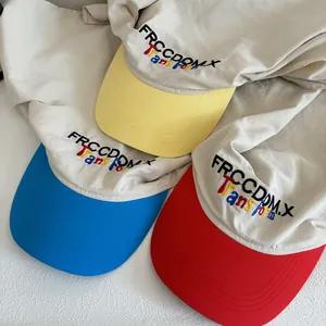 Top view of three baseball caps with embroidered letters and contrasting color brims