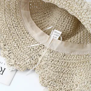 Detail of internal sweatband with adjustable strap and paper fiber label on straw hat