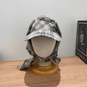 Checkered cotton-linen sun hat with tie-back design and embroidery on model head