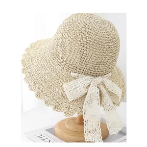 Chic handmade straw hat with wavy lace edges and a white ribbon bow for sun protection