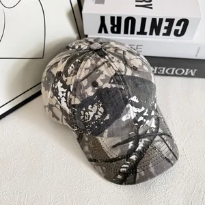Détail d'une casquette de baseball camouflage avec motif tacheté gris et beige sur fond blanc