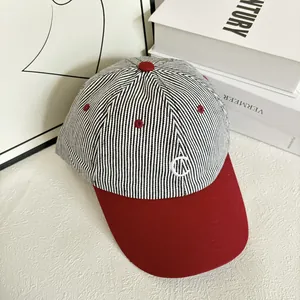 Detail of vintage striped baseball cap with C embroidery and contrast red visor