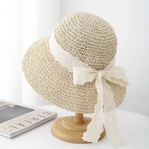 Elegante sombrero de paja beige con lazo de encaje en soporte de madera para la playa