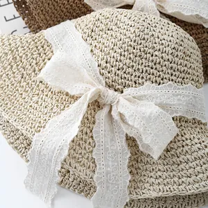Detalle de sombrero de paja tejido a mano con cinta de encaje blanco y lazo elegante