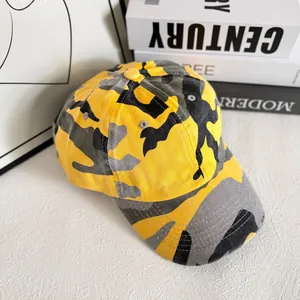 Détail de la casquette camouflage jaune avec coutures renforcées et œillets de ventilation