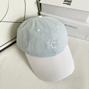 Detailed close-up of C letter embroidery on striped canvas baseball cap fabric