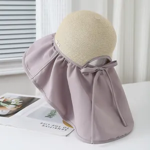 Dettaglio del cappello da sole anti-UV con top in paglia, tesa lilla e fiocco decorativo